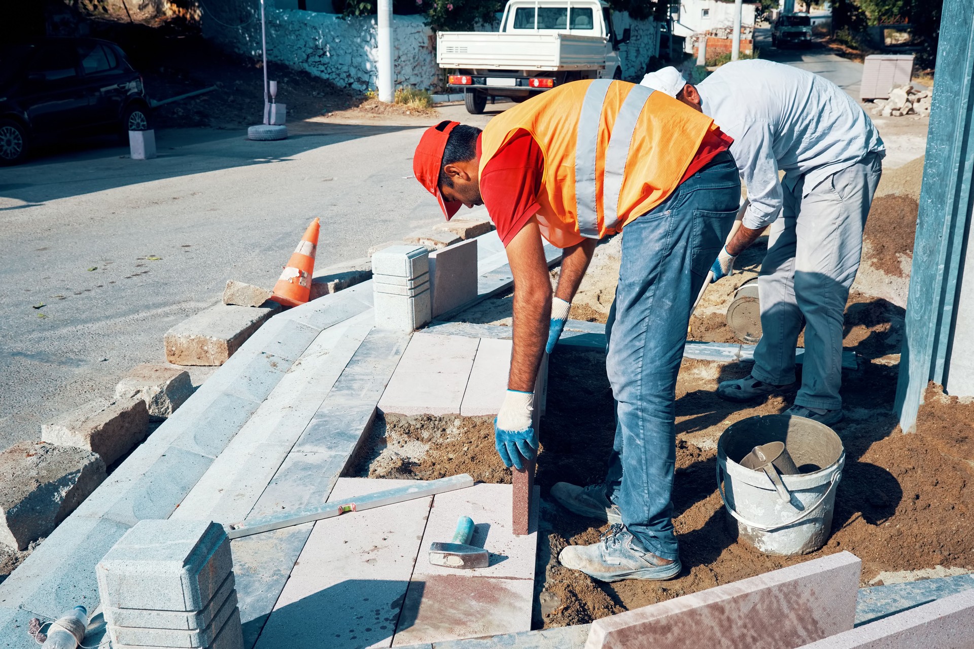 Pavement construction workers installing tiles to build a sidewalk